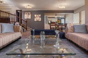 a living room with two couches and a glass table at Thimeli Hotel in Lygourio
