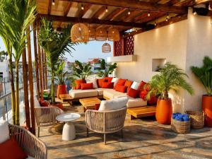 a patio with a couch and tables and chairs at NH Royal Urban Cartagena in Cartagena de Indias