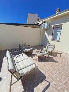 a patio with two chairs and a table on a building at Casa Elena Floris in Teulada