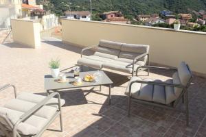 a patio with two chairs and a table on a roof at Casa Elena Floris in Teulada +4 photos