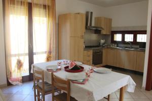 a kitchen with a table with a white table cloth at Casa Elena Floris in Teulada