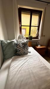a white bed in a room with a window at Idyllische Ferienwohnungen Die Rustikale mit Blick auf die Naab in Burglengenfeld +9 photos