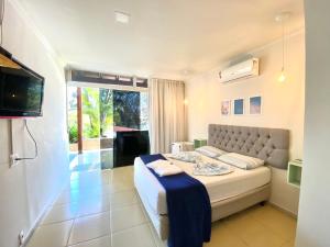 a bedroom with a bed and a television in it at Da Orla Pampulha Hostel in Belo Horizonte +74 photos