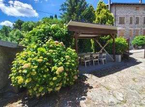 a gazebo with chairs and a table and flowers at Charme a Corniglio - Suite Cervo in Corniglio