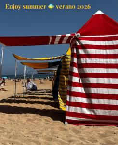 a red and white striped umbrella on the beach at Zen Casa House in Gijón