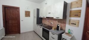 a small kitchen with white cabinets and a door at Kylix Home in Campobasso +22 photos