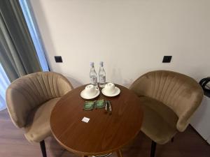 a wooden table with two chairs and bottles on it at Davos hotel and tours in Pʼarakʼar