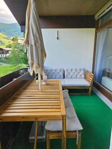 a table with an umbrella and a couch in a room at Malejo - HochkönigCard - Pool - Ski-in & Ski-out in Maria Alm am Steinernen Meer
