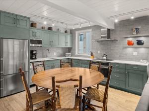 a kitchen with green cabinets and a wooden table at Lift One Condominiums - Unit 305 in Aspen