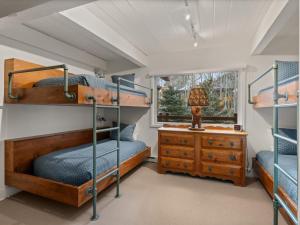 a bedroom with bunk beds and a dresser and a window at Lift One Condominiums - Unit 305 in Aspen