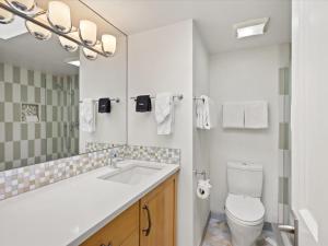 a white bathroom with a sink and a toilet at Lift One Condominiums - Unit 305 in Aspen +5 photos