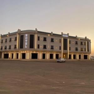 a large building with a car parked in a parking lot at فندق أونارا ستاي in Medina