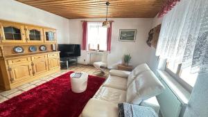 a living room with a white couch and a television at Idyllische Ferienwohnungen Die Rustikale mit Blick auf die Naab in Burglengenfeld