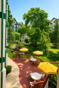 a patio with tables and yellow umbrellas at Carriage Place in Branson