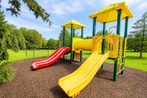 a playground with three slides in a park at Carriage Place in Branson