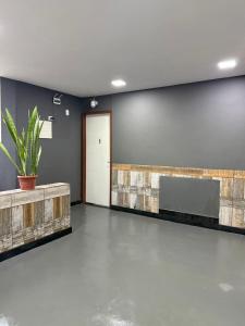 a waiting room with a potted plant on a wall at Suites Prime in Marataizes