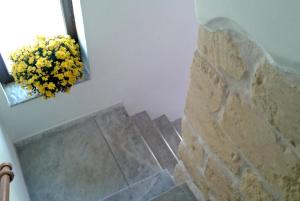 un baño con espejo y un ramo de flores amarillas en Casa Romantica, en Sorso