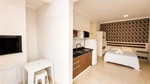 a small room with a bed and a kitchen at Van Gogh by OlaMar Bombinhas in Bombinhas +9 photos