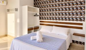 a bedroom with a bed with a towel on it at Van Gogh by OlaMar Bombinhas in Bombinhas