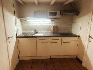 a small kitchen with a sink and a microwave at B&B In Bruges in Bruges