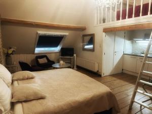 a bedroom with a large bed and a kitchen at B&B In Bruges in Bruges