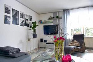a living room with a vase of flowers on a table at HarzApart-Goslar in Goslar