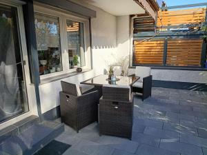 a patio with a table and wicker chairs at HarzApart-Goslar in Goslar