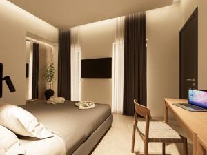 a bedroom with a bed and a desk with a laptop at Zanetos Prasonisi in Prasonisi