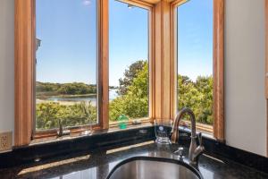 a kitchen sink with a view of a river at Waterfront Escape Game Room Dog Friendly in Chatham