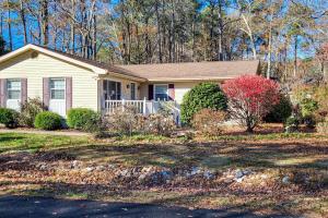 a small white house with a tree in the yard at The Nest in Ocean Pines