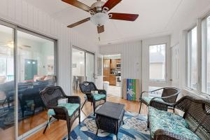 a living room with chairs and a ceiling fan at Teal Haven in Ocean Pines
