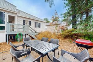 a patio with a table and chairs and a grill at Teal Haven in Ocean Pines