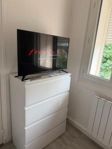 a tv on top of a dresser with a tv on it at Le petit port de boucain in Port-de-Bouc