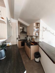 a kitchen with wooden cabinets and a black counter top at Cozy home in Donja Lastva +29 photos