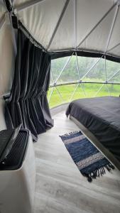 a bedroom in a tent with a bed and a rug at Dôme Romanov in Saint-René-de-Matane