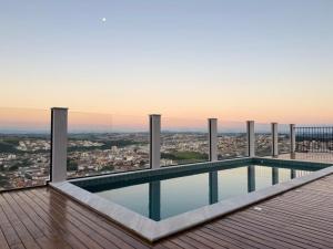 a swimming pool on the roof of a building at Studio Moderno com Internet e Garagem. in Três Corações
