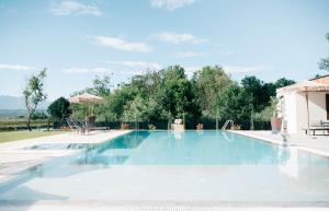 a swimming pool with blue water and trees in the background at Salinas Nest - Ulcinj Stoj Ada Bojana in Ulcinj