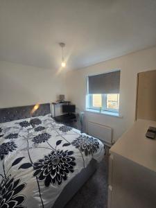 a bedroom with a bed with a flower pattern on it at Peachy velvet room in a flat in Rushall