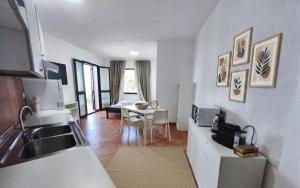 a kitchen with a sink and a table in a room at Il Corbezzolo Tropea Residence in Tropea