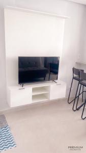a living room with a tv on a white wall at Laguna Sun Set in Salinópolis