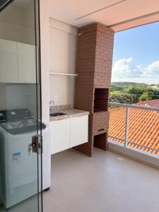 a kitchen with a stove and a balcony at Laguna Sun Set in Salinópolis