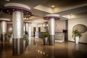 a lobby with pillars and plants in a building at Euronapa Hotel in Ayia Napa +140 photos