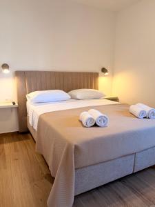 a bedroom with a large bed with towels on it at Šaravanja in Bibinje