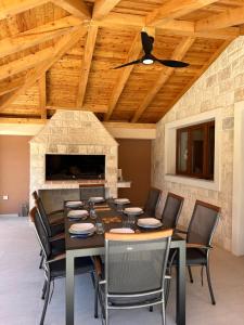 a dining room with a table and chairs and a stone fireplace at Šaravanja in Bibinje