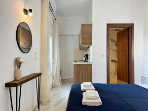 a bedroom with a blue bed and a mirror at Siblings by the Sea in Skala Marion