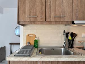 a kitchen with a stainless steel sink and wooden cabinets at Siblings by the Sea in Skala Marion +43 photos