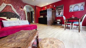 a living room with red walls and a red couch at Le Rubis - Votre cocon d'orient in Calais