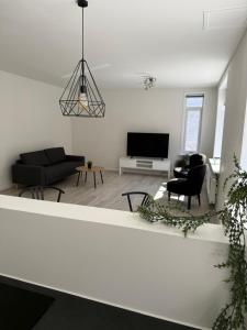 a living room with a couch and a tv at Lille Vedelsborg 1 in Vejle
