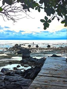 a wooden pathway on a beach with the ocean at Hôtel La Baleine in Sainte Marie