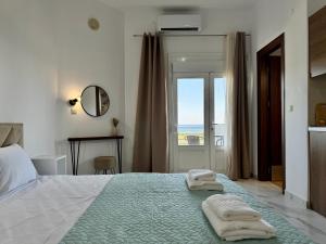 a bedroom with a bed with two towels on it at Siblings by the Sea in Skala Marion